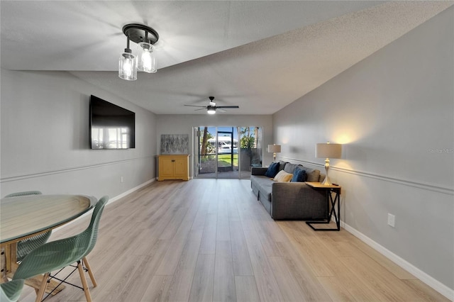 1028 Apollo Beach Blvd Unit 21, Apollo Beach, FL 33572 - living room featuring light wood-style flooring, baseboards, ceiling fan, and a textured ceiling