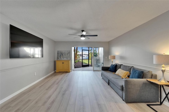 1028 Apollo Beach Blvd Unit 21, Apollo Beach, FL 33572 - living room with ceiling fan, light wood-style flooring, baseboards, and a textured ceiling