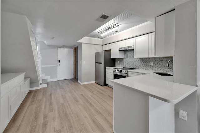 1028 Apollo Beach Blvd Unit 21, Apollo Beach, FL 33572 - kitchen featuring a sink, stainless steel appliances, light wood finished floors, backsplash, and light stone countertops