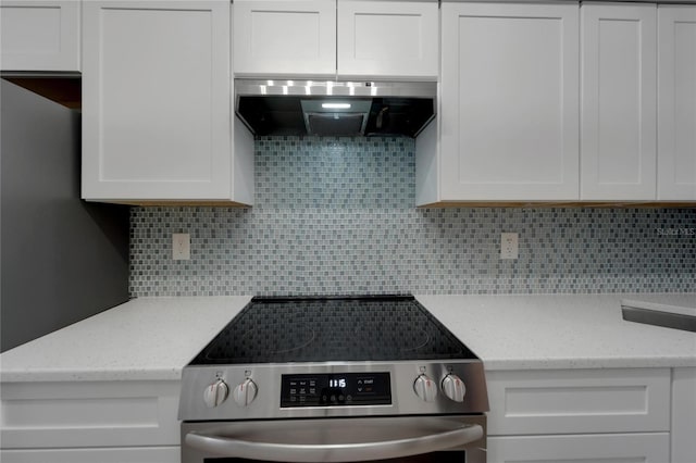 1028 Apollo Beach Blvd Unit 21, Apollo Beach, FL 33572 - kitchen with electric stove, exhaust hood, white cabinetry, and backsplash