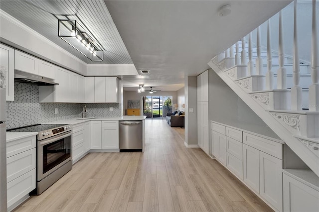 1028 Apollo Beach Blvd Unit 21, Apollo Beach, FL 33572 - kitchen with stainless steel appliances, white cabinetry, under cabinet range hood, a sink, and crown molding