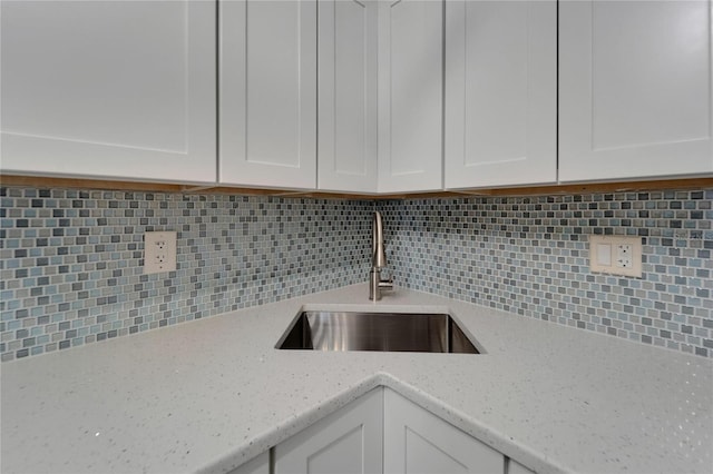 1028 Apollo Beach Blvd Unit 21, Apollo Beach, FL 33572 - kitchen with a sink, white cabinets, decorative backsplash, and light stone countertops