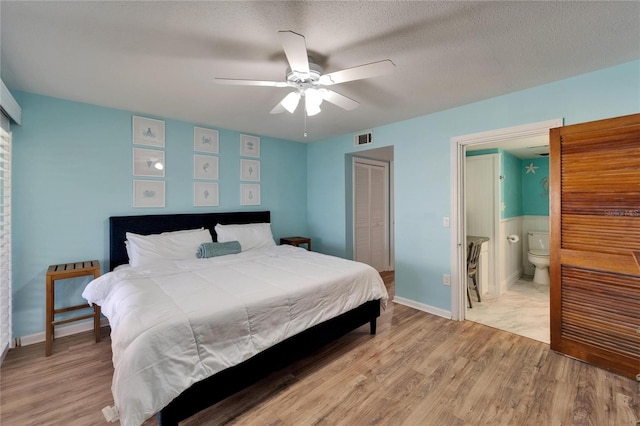 1028 Apollo Beach Blvd Unit 21, Apollo Beach, FL 33572 - bedroom featuring light wood-type flooring, a closet, ensuite bathroom, and a ceiling fan