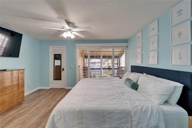 1028 Apollo Beach Blvd Unit 21, Apollo Beach, FL 33572 - bedroom with access to exterior, wood finished floors, a textured ceiling, baseboards, and a ceiling fan