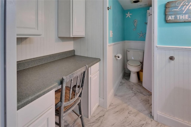 1028 Apollo Beach Blvd Unit 21, Apollo Beach, FL 33572 - bathroom with marble look tiles, toilet, and a wainscoted wall