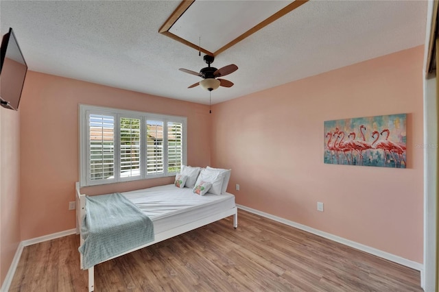 1028 Apollo Beach Blvd Unit 21, Apollo Beach, FL 33572 - bedroom with wood finished floors, attic access, baseboards, a textured ceiling, and a ceiling fan