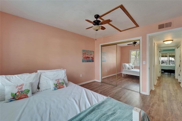1028 Apollo Beach Blvd Unit 21, Apollo Beach, FL 33572 - bedroom featuring wood finished floors, baseboards, a ceiling fan, a closet, and attic access