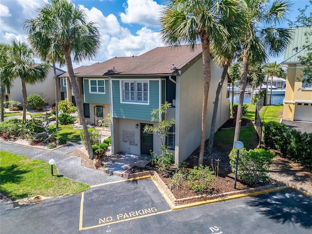 1028 Apollo Beach Blvd Unit 21, Apollo Beach, FL 33572 - view of front of home featuring stucco siding, uncovered parking, and a water view
