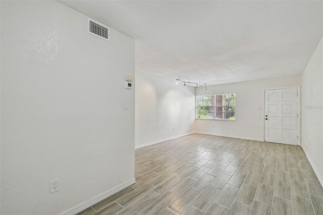 208 Danube Ave Unit 101, Tampa, FL 33606 - empty room with baseboards, light wood-type flooring, and a textured ceiling