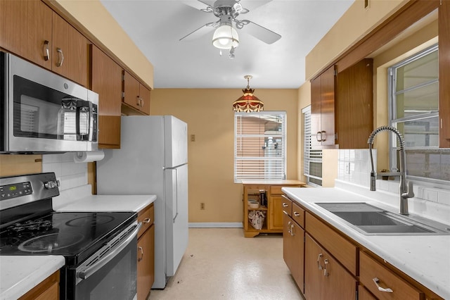 2222 Euclid Cir N, Clearwater, FL 33764 - kitchen featuring appliances with stainless steel finishes, a sink, and brown cabinets
