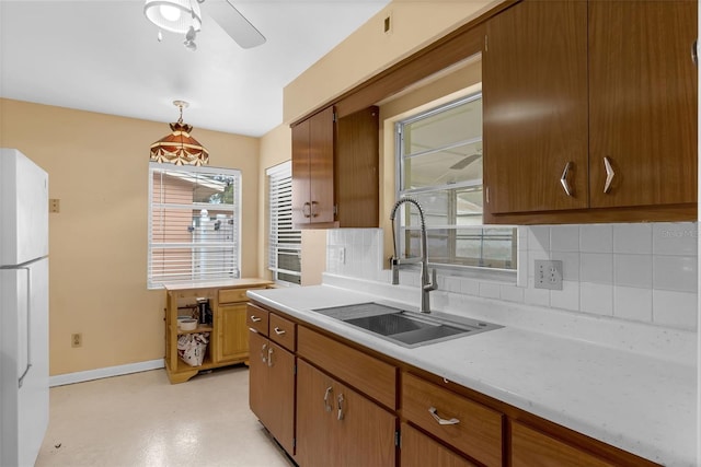 2222 Euclid Cir N, Clearwater, FL 33764 - kitchen with freestanding refrigerator, light countertops, backsplash, a sink, and baseboards