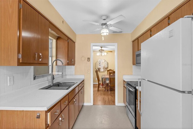 2222 Euclid Cir N, Clearwater, FL 33764 - kitchen featuring freestanding refrigerator, range with electric cooktop, a ceiling fan, a sink, and decorative backsplash