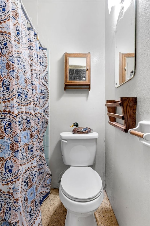 2222 Euclid Cir N, Clearwater, FL 33764 - full bathroom with speckled floor, toilet, and a shower with shower curtain