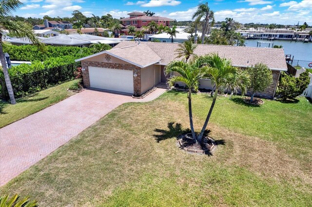 11628 Grove St, Seminole, FL 33772 - view of front of property with decorative driveway, a garage, a water view, roof with shingles, and a residential view