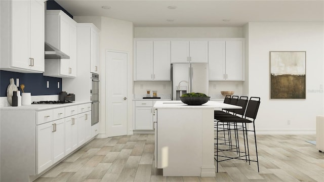 11761 E 71st Ter, Palmetto, FL 34221 - kitchen featuring white refrigerator with ice dispenser, exhaust hood, light wood-style flooring, and an island with sink
