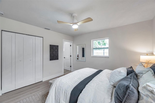 bedroom featuring wood finished floors, a closet, baseboards, and a ceiling fan
