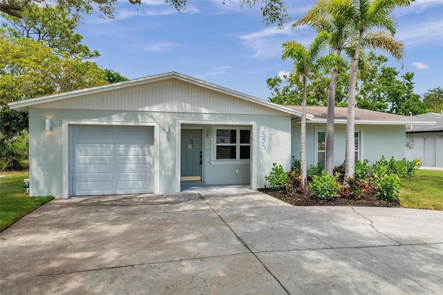 ranch-style house with an attached garage, driveway, and stucco siding