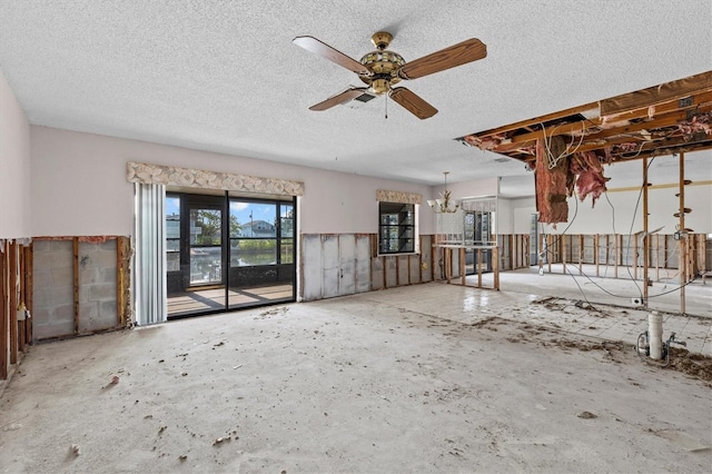 4274 Deleon Dr, Hernando Beach, FL 34607 - unfurnished living room featuring a ceiling fan, a textured ceiling, and a chandelier