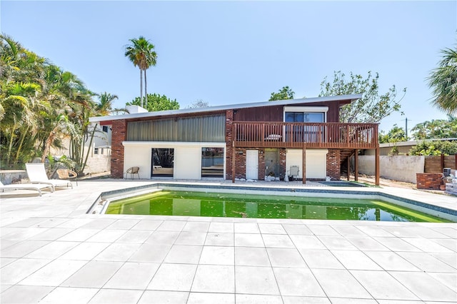31 Dolphin Dr, Treasure Island, FL 33706 - rear view of property with a patio area, brick siding, an outdoor pool, a wooden deck, and stairway