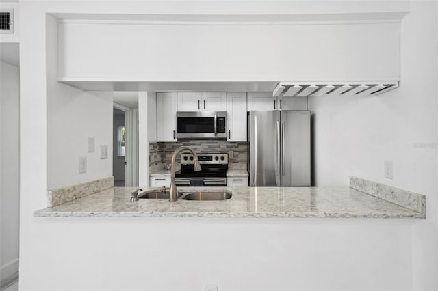 3102 W Horatio St Unit 13, Tampa, FL 33609 - kitchen with appliances with stainless steel finishes, a sink, backsplash, and a peninsula