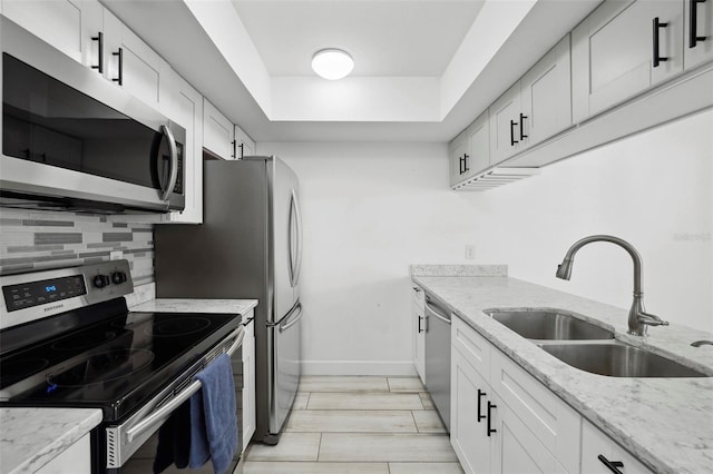 3102 W Horatio St Unit 13, Tampa, FL 33609 - kitchen featuring appliances with stainless steel finishes, a sink, tasteful backsplash, baseboards, and light stone counters