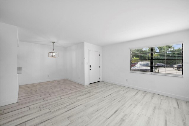 3102 W Horatio St Unit 13, Tampa, FL 33609 - unfurnished room with wood finished floors, baseboards, and a chandelier
