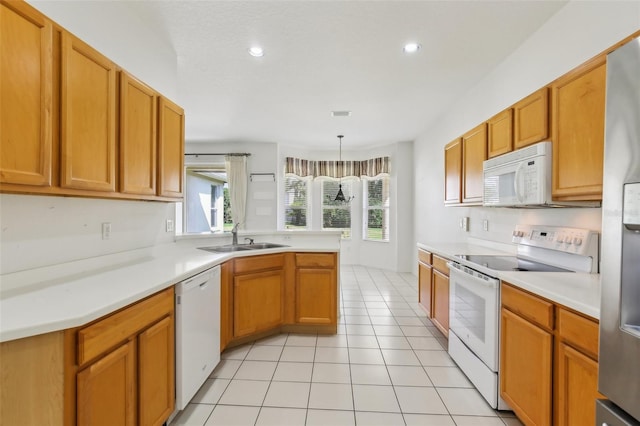 3311 Stonebridge Trl, Valrico, FL 33596 - kitchen with white appliances, a sink, light countertops, a peninsula, and light tile patterned flooring