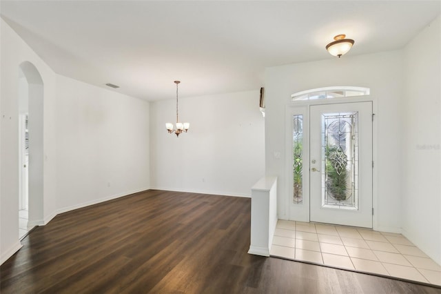 3311 Stonebridge Trl, Valrico, FL 33596 - foyer entrance with wood finished floors, a chandelier, arched walkways, and baseboards