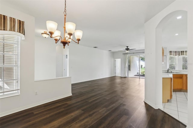 3311 Stonebridge Trl, Valrico, FL 33596 - unfurnished living room with arched walkways, a ceiling fan, light wood-type flooring, a chandelier, and baseboards