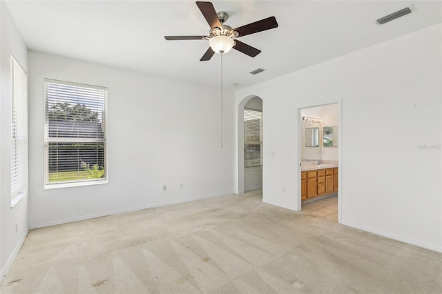 3311 Stonebridge Trl, Valrico, FL 33596 - unfurnished room featuring arched walkways, light colored carpet, a ceiling fan, baseboards, and a sink