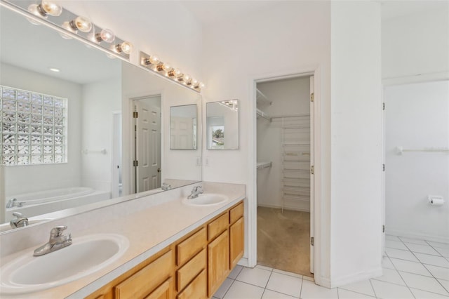 3311 Stonebridge Trl, Valrico, FL 33596 - bathroom with tile patterned floors, double vanity, a garden tub, a spacious closet, and baseboards
