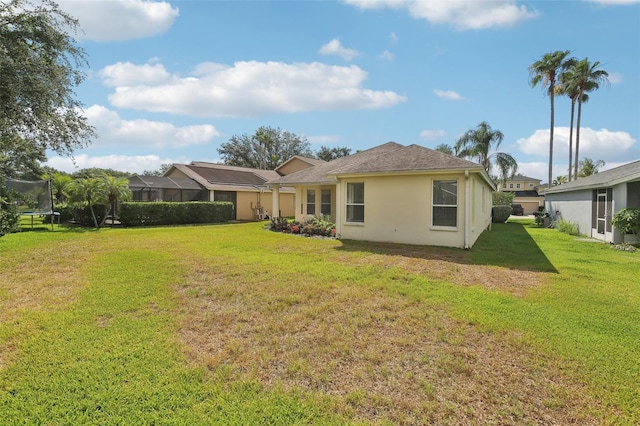 3311 Stonebridge Trl, Valrico, FL 33596 - rear view of house featuring a trampoline, a lawn, and stucco siding