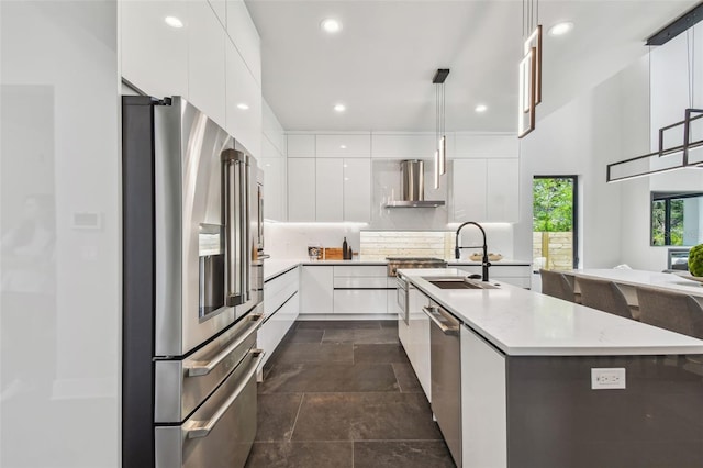 kitchen featuring stainless steel appliances, modern cabinets, a sink, white cabinetry, and recessed lighting