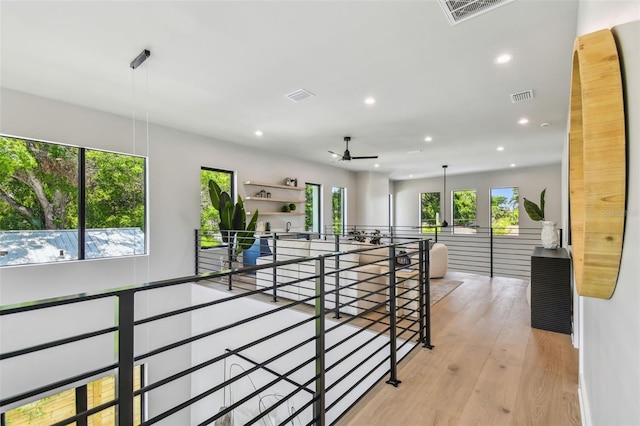 hall with an upstairs landing, recessed lighting, and wood finished floors