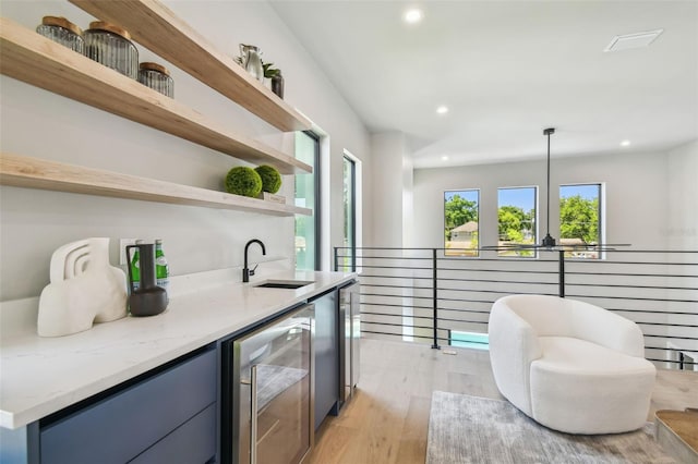 indoor wet bar featuring beverage cooler, recessed lighting, and light wood-style flooring