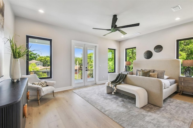 bedroom with access to outside, multiple windows, light wood-type flooring, and recessed lighting