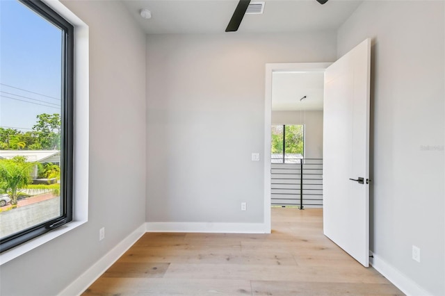 unfurnished room featuring a ceiling fan, light wood-type flooring, a smoke detector, and baseboards