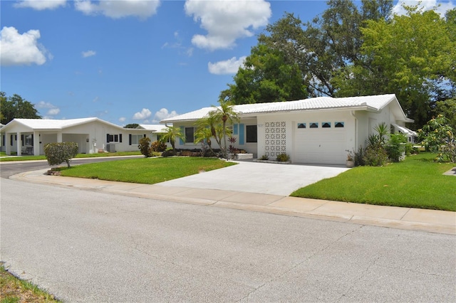 9639 Mainlands Blvd E, Pinellas Park, FL 33782 - single story home with a garage, a front lawn, concrete driveway, and stucco siding