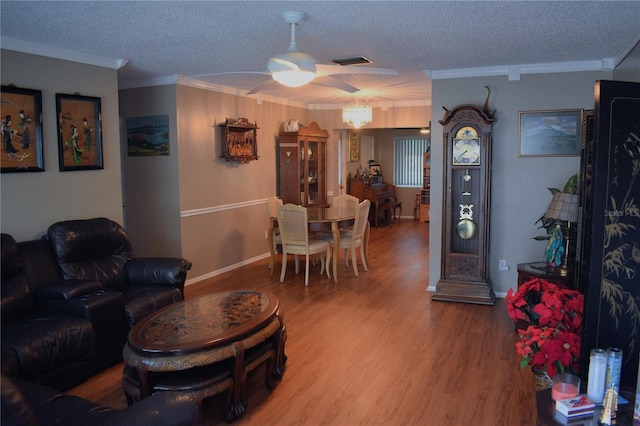9639 Mainlands Blvd E, Pinellas Park, FL 33782 - living area with a ceiling fan, a textured ceiling, ornamental molding, wood finished floors, and baseboards