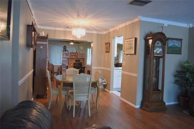 9639 Mainlands Blvd E, Pinellas Park, FL 33782 - dining room with a textured ceiling, a chandelier, wood finished floors, ornamental molding, and a ceiling fan
