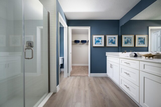 6236 SW 95th Pl, Ocala, FL 34476 - bathroom featuring a stall shower, wood finished floors, vanity, a textured ceiling, and baseboards