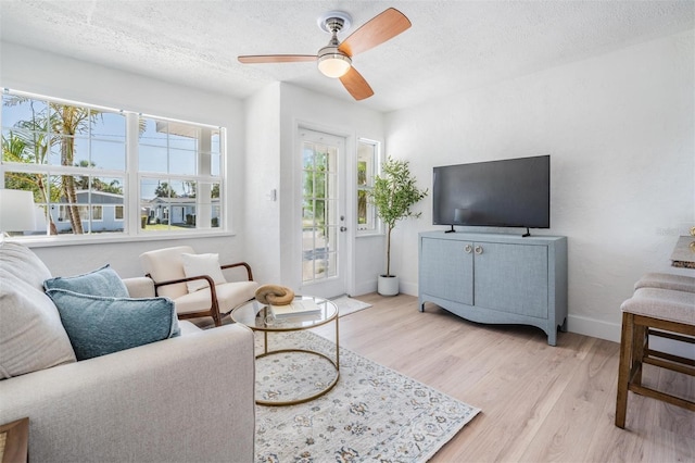 13304 2nd St E, Madeira Beach, FL 33708 - living area featuring light wood-style floors, a textured ceiling, baseboards, and ceiling fan
