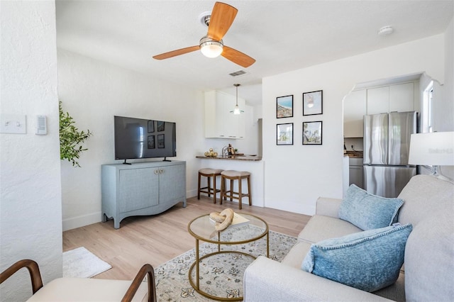 13304 2nd St E, Madeira Beach, FL 33708 - living room with ceiling fan, light wood-style flooring, and baseboards