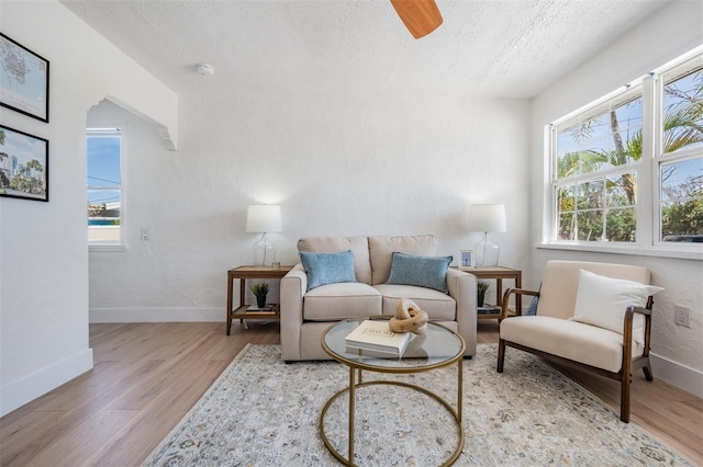 13304 2nd St E, Madeira Beach, FL 33708 - living room with a textured ceiling, plenty of natural light, wood finished floors, and baseboards