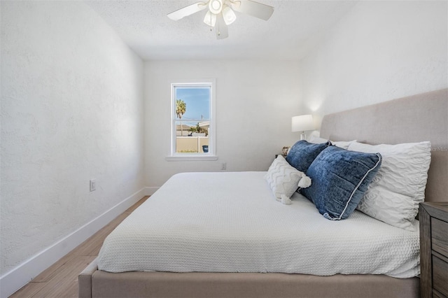 13304 2nd St E, Madeira Beach, FL 33708 - bedroom featuring wood finished floors, baseboards, ceiling fan, and a textured wall