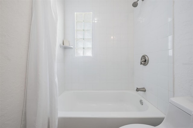 13304 2nd St E, Madeira Beach, FL 33708 - bathroom featuring toilet, a textured wall, and shower / bathtub combination with curtain