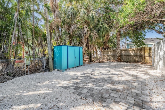 13304 2nd St E, Madeira Beach, FL 33708 - view of patio / terrace featuring a storage shed, a fenced backyard, and an outdoor structure