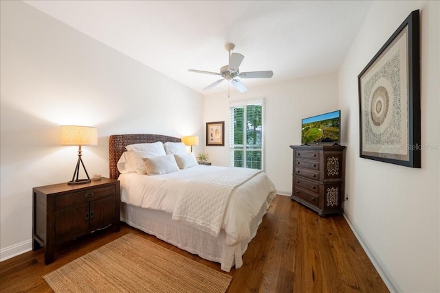 bedroom featuring wood finished floors, baseboards, and ceiling fan