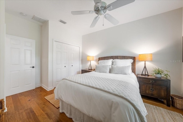 bedroom featuring wood finished floors, a closet, baseboards, and ceiling fan