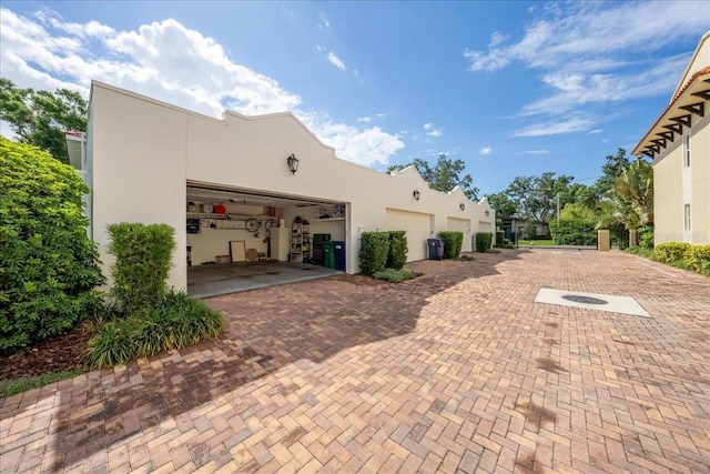 view of home's exterior with stucco siding and decorative driveway